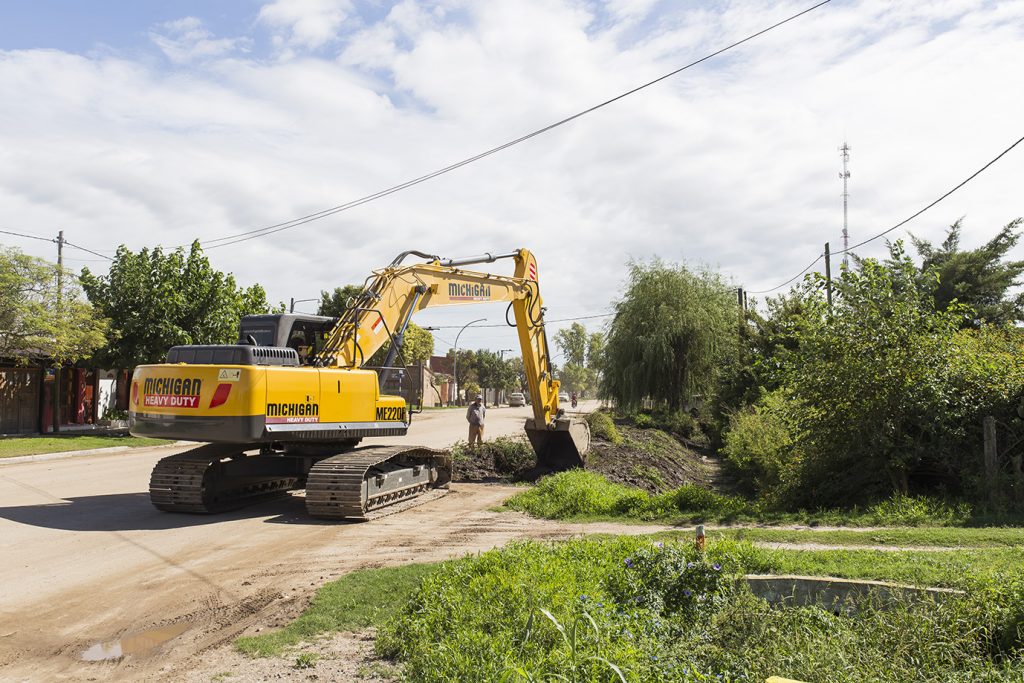 Personal municipal limpia canales sobre calle Perito Moreno